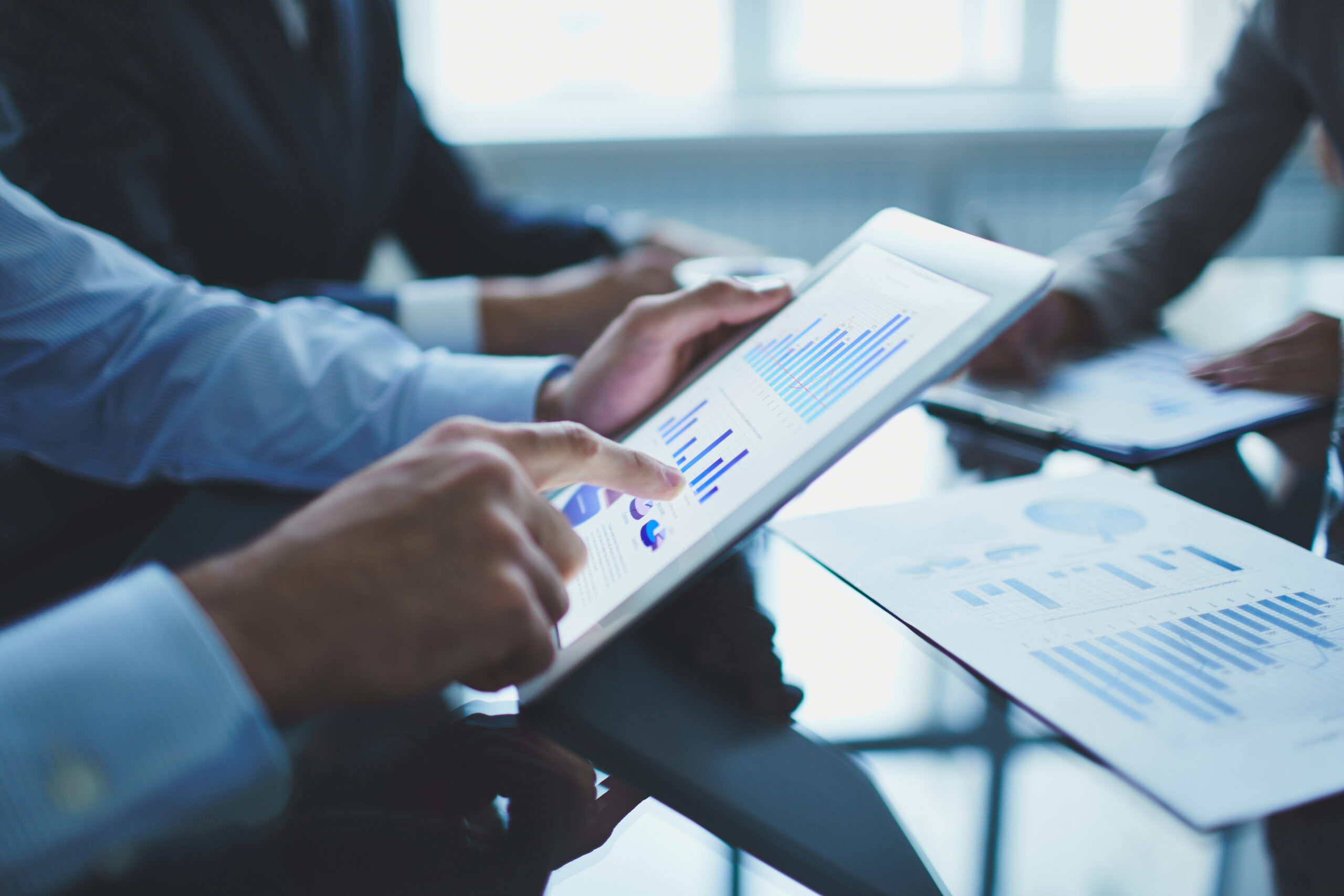 Analyzing electronic document Image of businessperson pointing at document in touchpad at meeting
